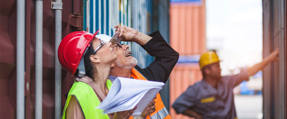 Picture of people in hardhats looking at shipping crate